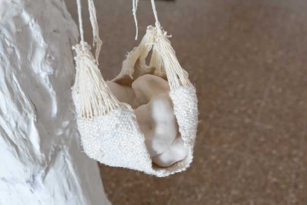 Woven silk and ceramic figure close-up